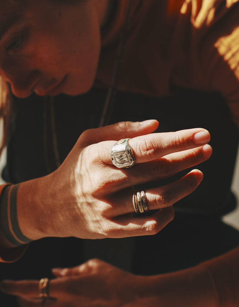 lifestyle photo image of woman's hand wearing stacking rings and Mother Mary sterling silver souvenir ring