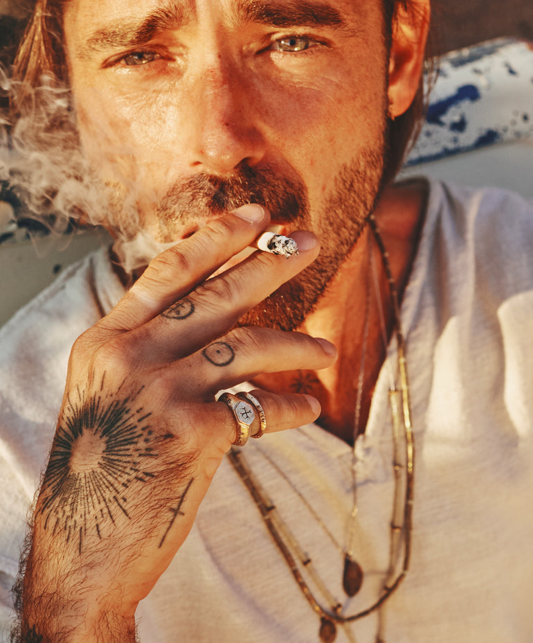 lifestyle photo image of male model smoking cigarette, wearing Sacred Love ring