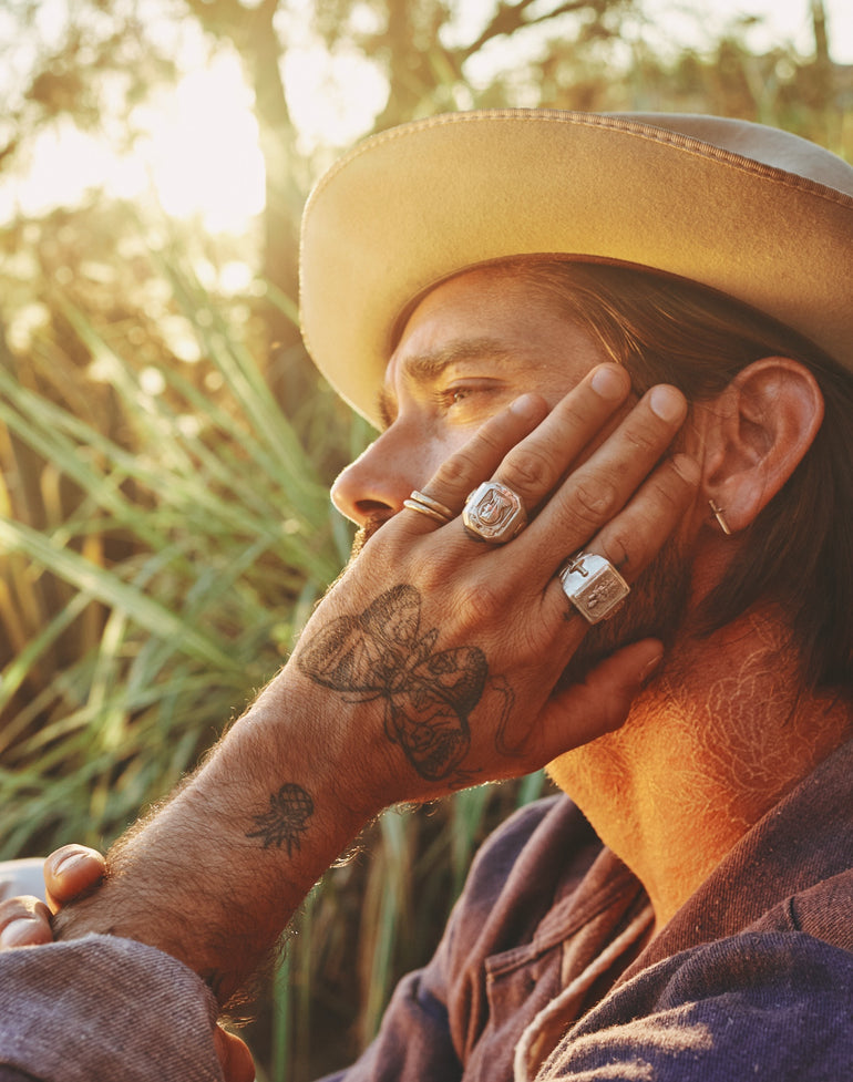 lifestyle photo image of man's face and hand wearing sterling silver religious souvenir biker ring